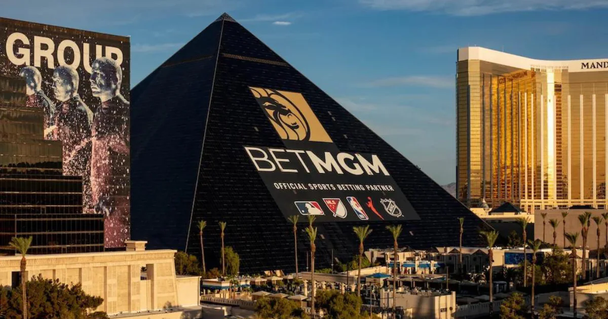 Luxor Hotel pyramid featuring BetMGM logo and sports league icons, with Mandalay Bay Hotel in the background.